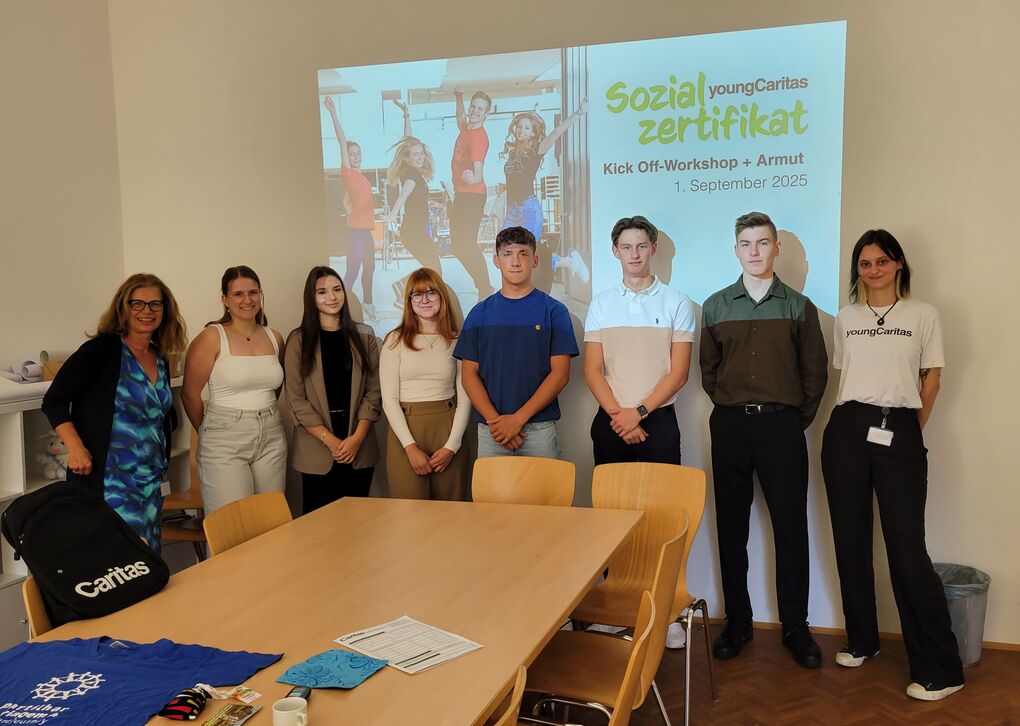 Eine Gruppe Jugendlicher vor einer PowerPoint mit dem Titel "Sozialzertifikat".