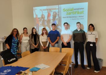 Eine Gruppe Jugendlicher vor einer PowerPoint mit dem Titel "Sozialzertifikat".
