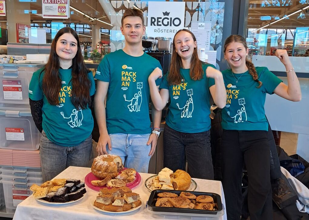 Jugendliche verkaufen Kuchen. Alle tragen T-Shirts mit dem Aufdruck "72 Stunden ohne Kompromiss"
