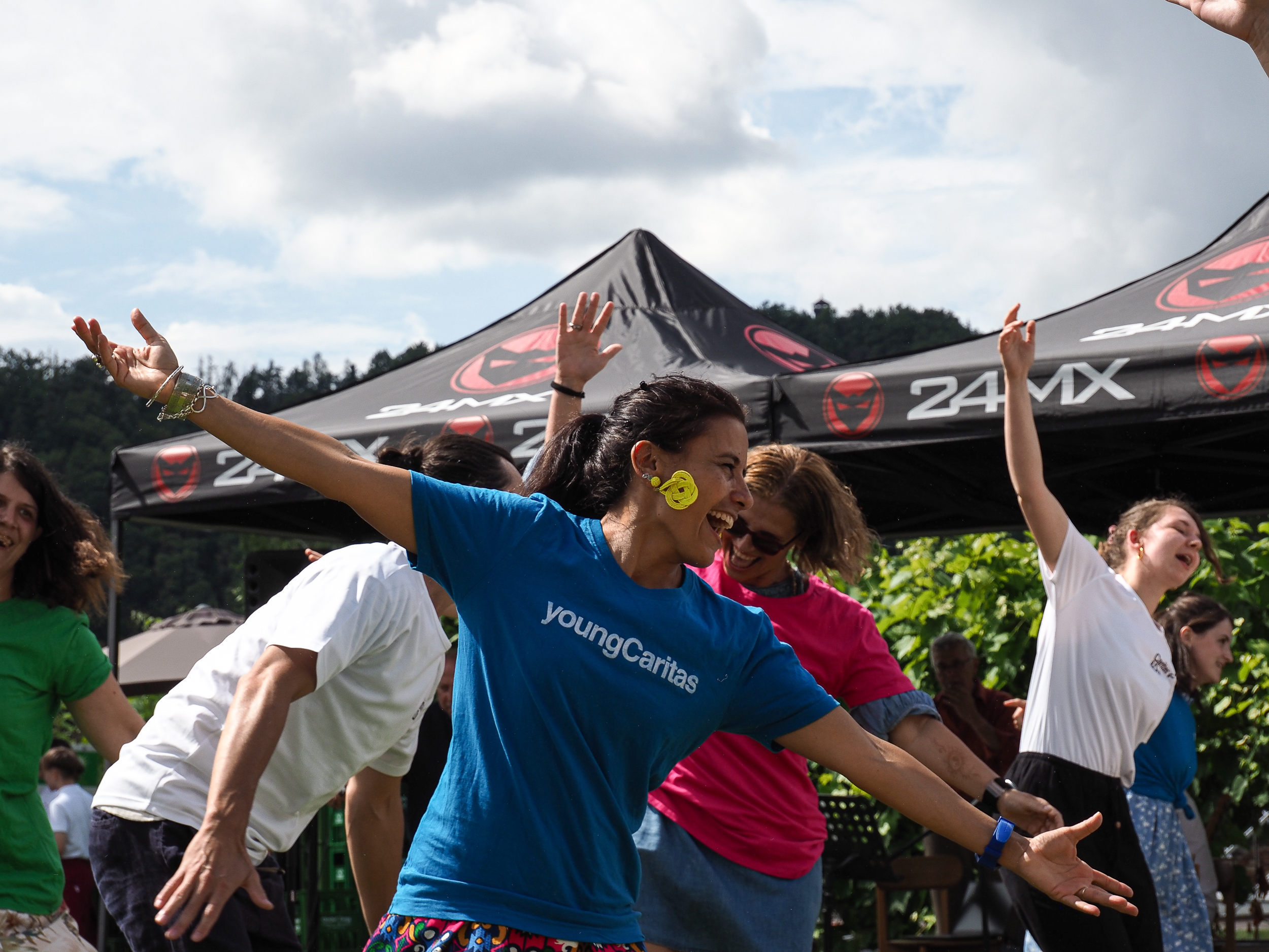 Eine Frau im youngCaritas-T-Shirt lächelt und posiert.