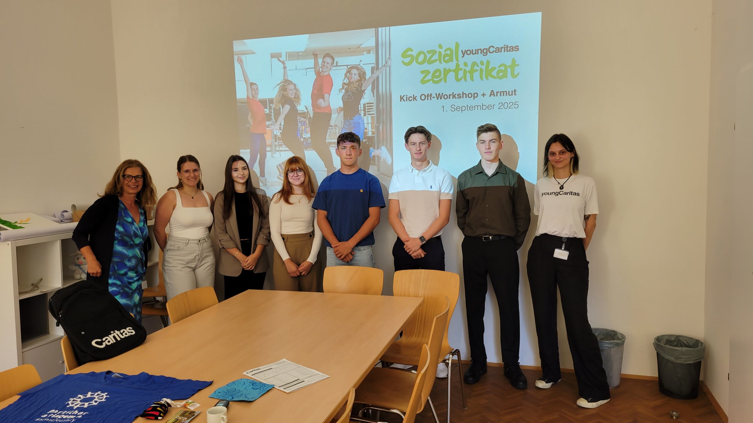 Gruppenfoto: Die Lehrlinge stehen vor einer PowerPoint-Projektion mit der Titelfolie: 